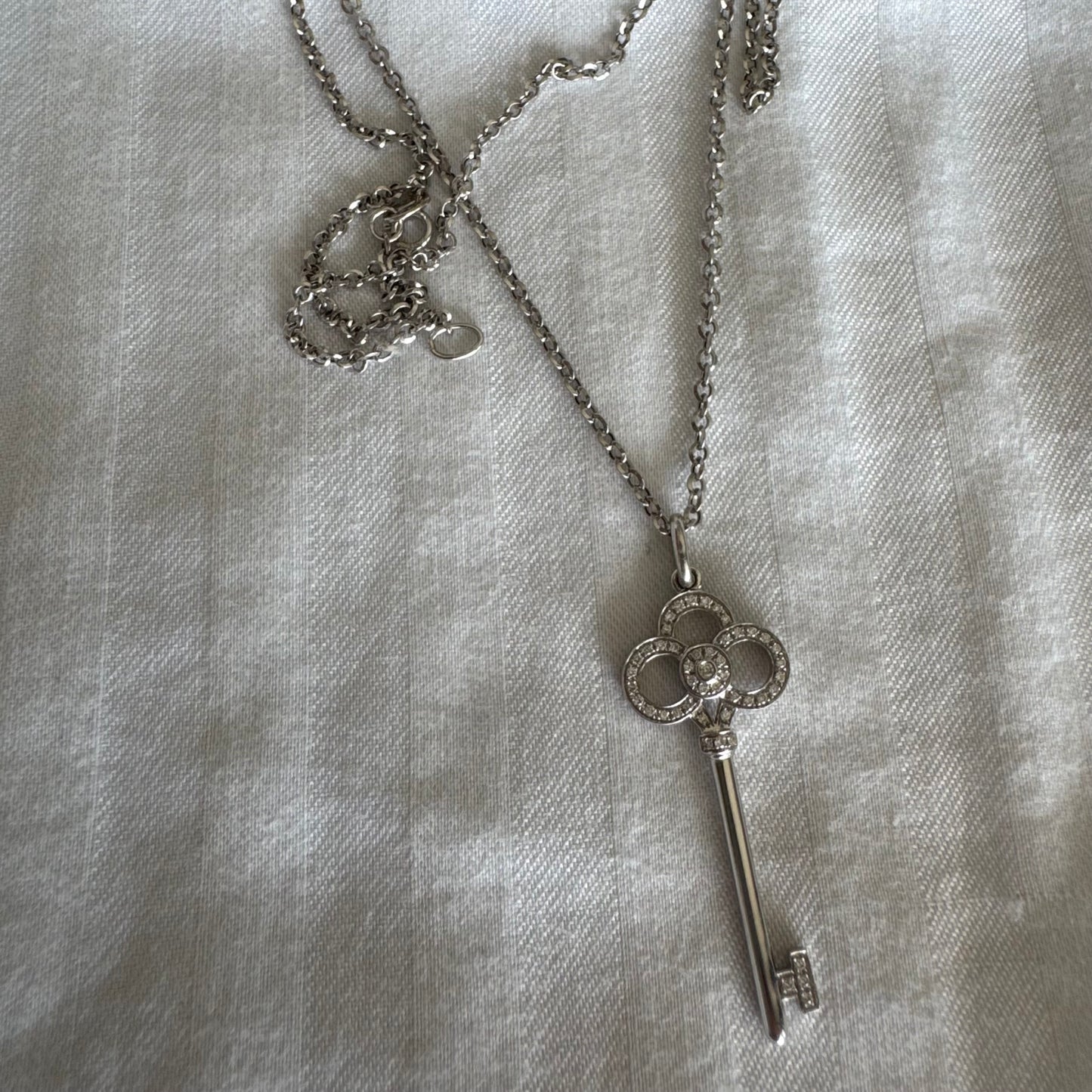 תליון מפתח אייקוני של Tiffany & Co. זהב לבן 18 קראט משובץ יהלומים עדינים.