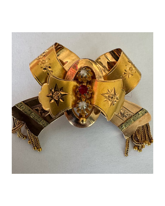 תליון זהב צהוב 18 קראט בעיצוב סרט (bow) עשיר עם חריטות עבודת יד ודוגמאות כוכב קלאסיות.