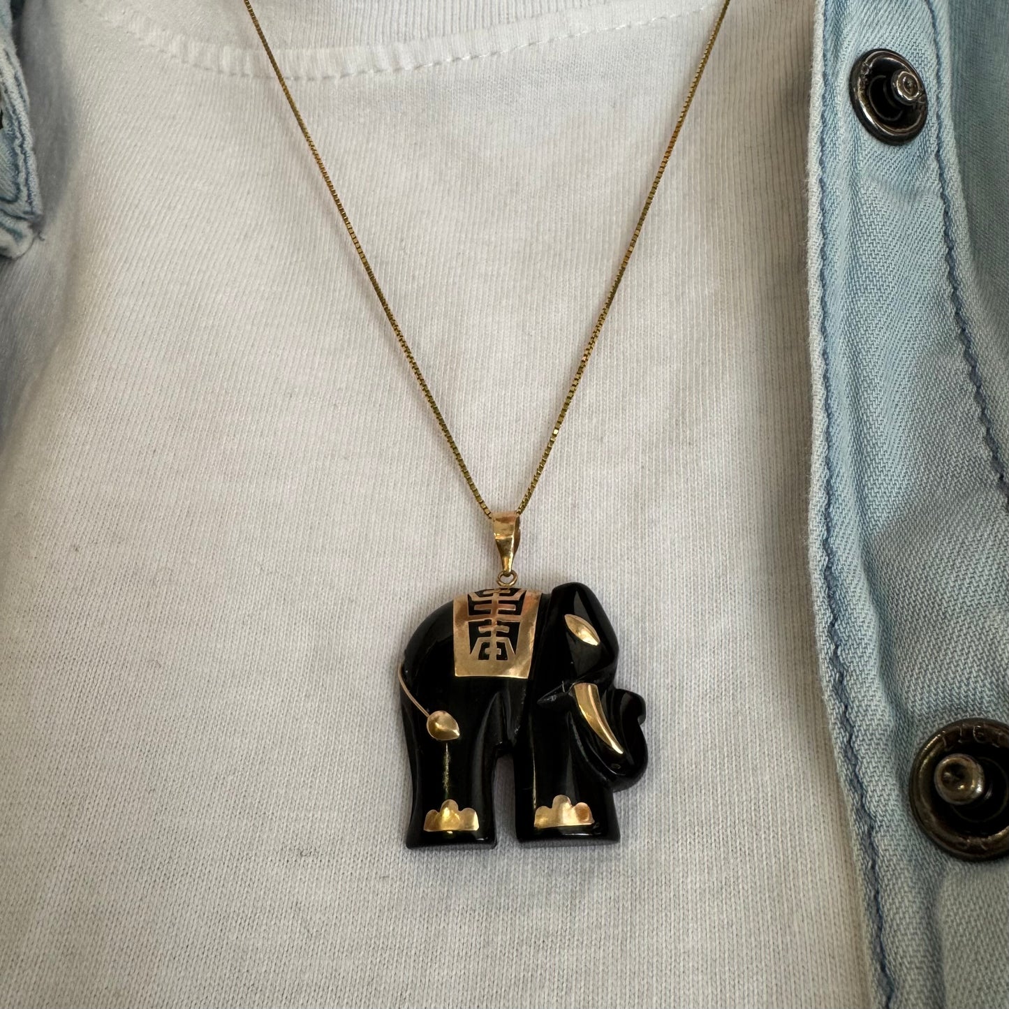 תליון זהב 9 קראט בעיצוב ייחודי ומלא נוכחות של פיל אפריקאי, המשלב גוף שחור מלוטש עם עיטורי זהב עדינים.