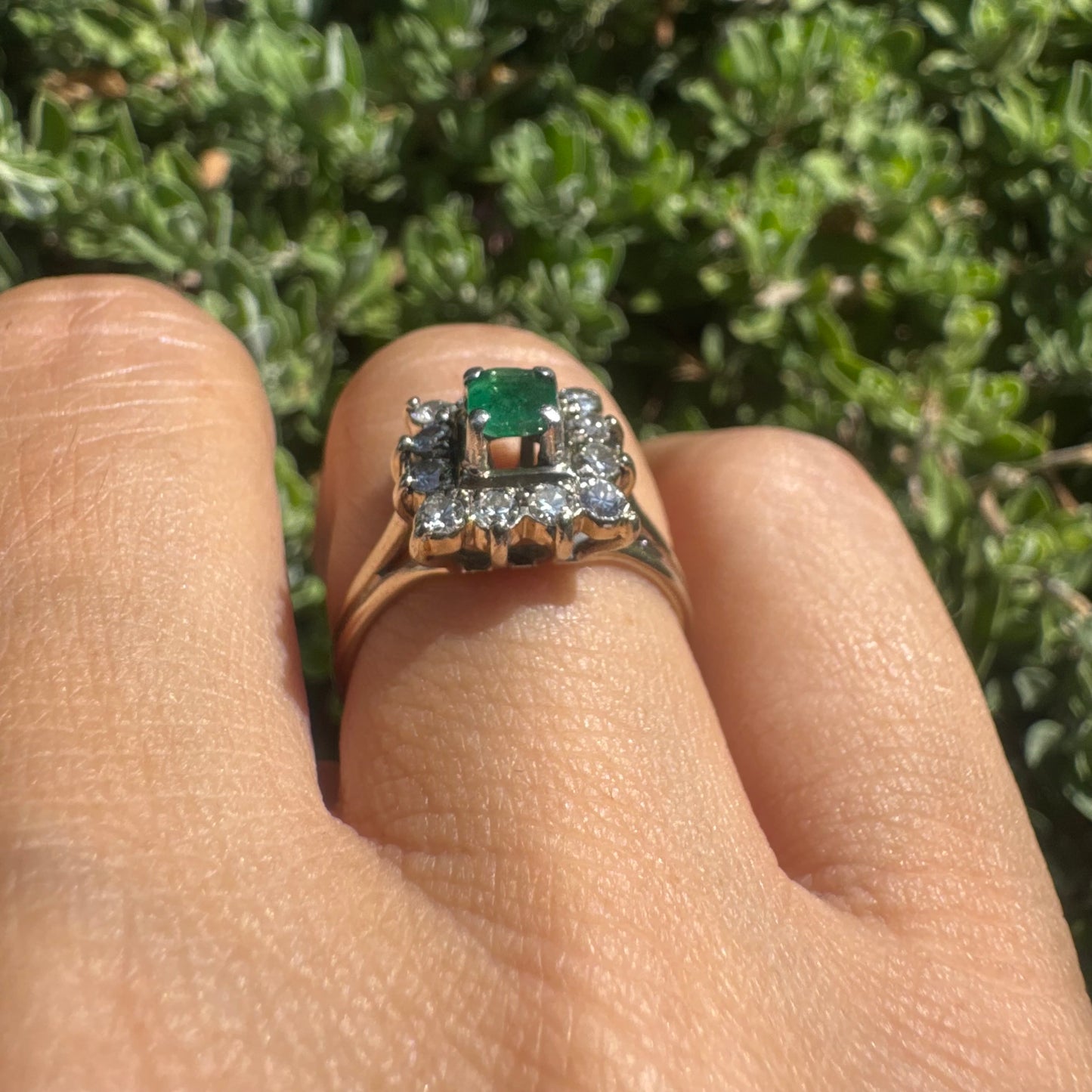 18K gold ring set with a vibrant square-cut Emerald surrounded by a sparkling halo of Diamonds.