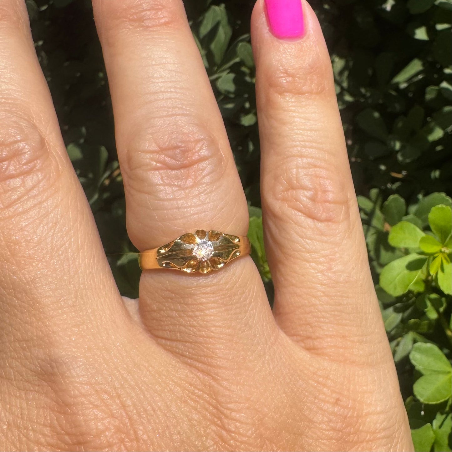 18K gold ring set with a small sparkling diamond at the center.