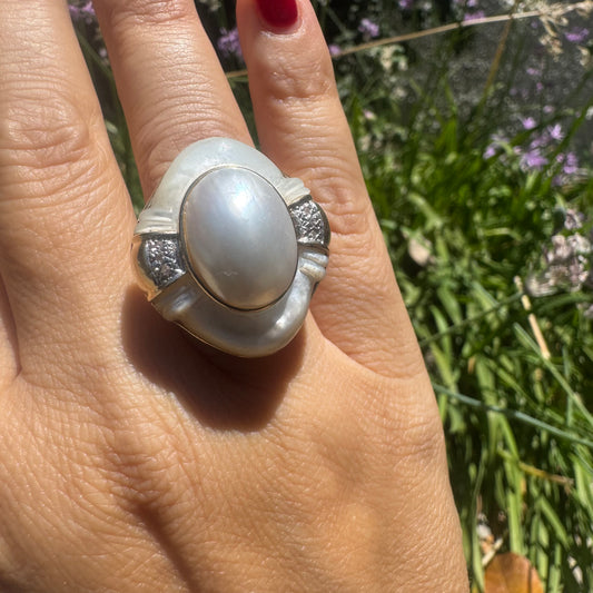 14K gold ring set with a natural mother-of-pearl centerpiece framed by delicate diamond accents