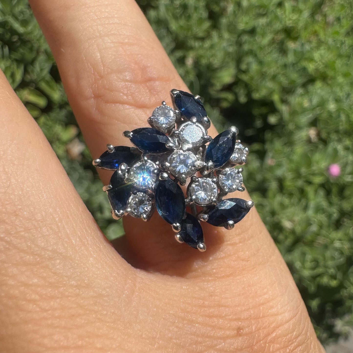 18K gold cluster ring featuring marquise-cut blue sapphires and round brilliant Diamonds arranged in a floral design.