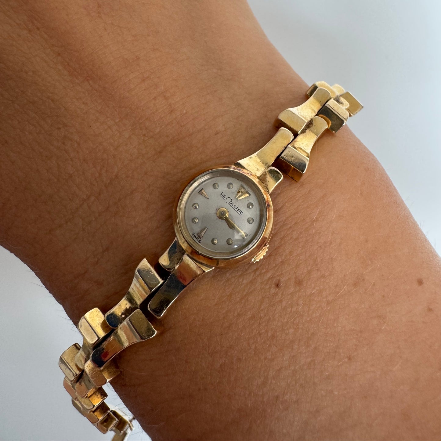 שעון נשים של Jaeger-LeCoultre מזהב 18 קראט, בעל צמיד אינטגרלי בעיצוב פיסולי ולוח מחוגים מינימליסטי ואלגנטי.