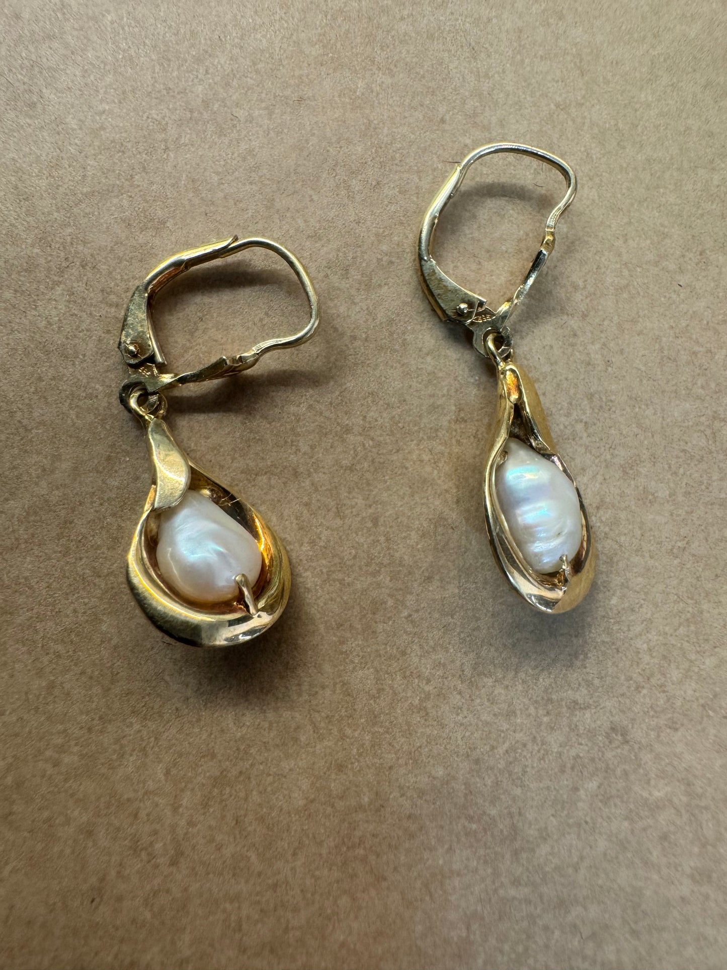 עגילי זהב צהוב 14 קראט משובצים פניני בארוק בעיצוב נוזלי ורך שמדגיש את היופי הטבעי של הפנינה