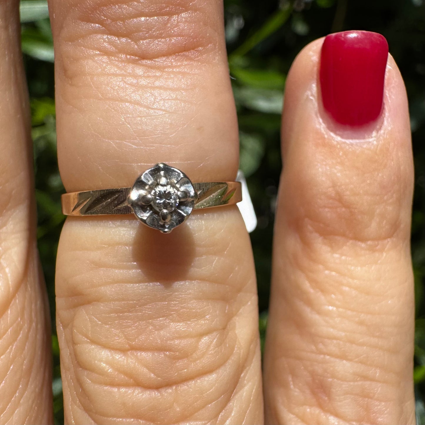 14K gold ring with a delicate floral-style setting, set with a small central Diamond.