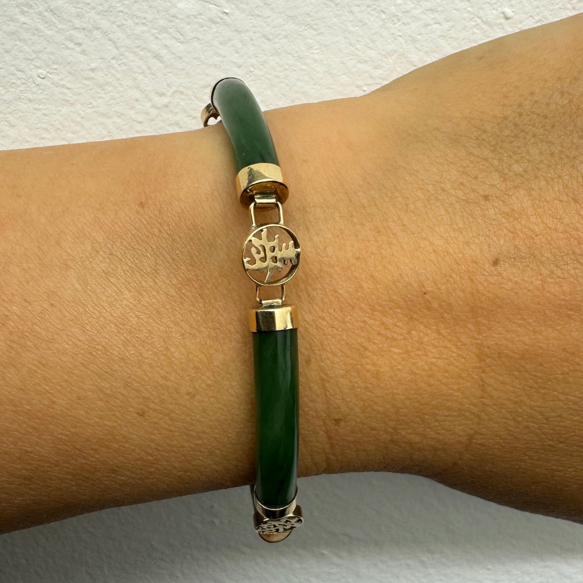 צמיד זהב צהוב 18 קראט משובץ&nbsp;אבני ג’ייד ירוקות עם עיטורי זהב בעיצוב אסייתי מסורתי – שילוב הרמוני של אלגנטיות, משמעות רוחנית וסטייל ייחודי