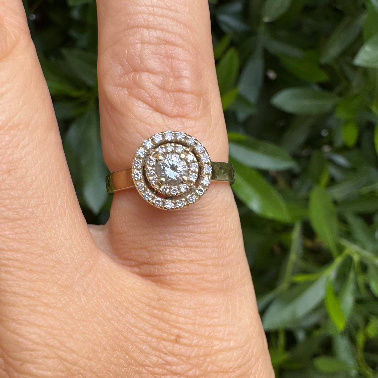 14K gold ring with a round center Diamond, surrounded by two rows of small sparkling Diamonds.