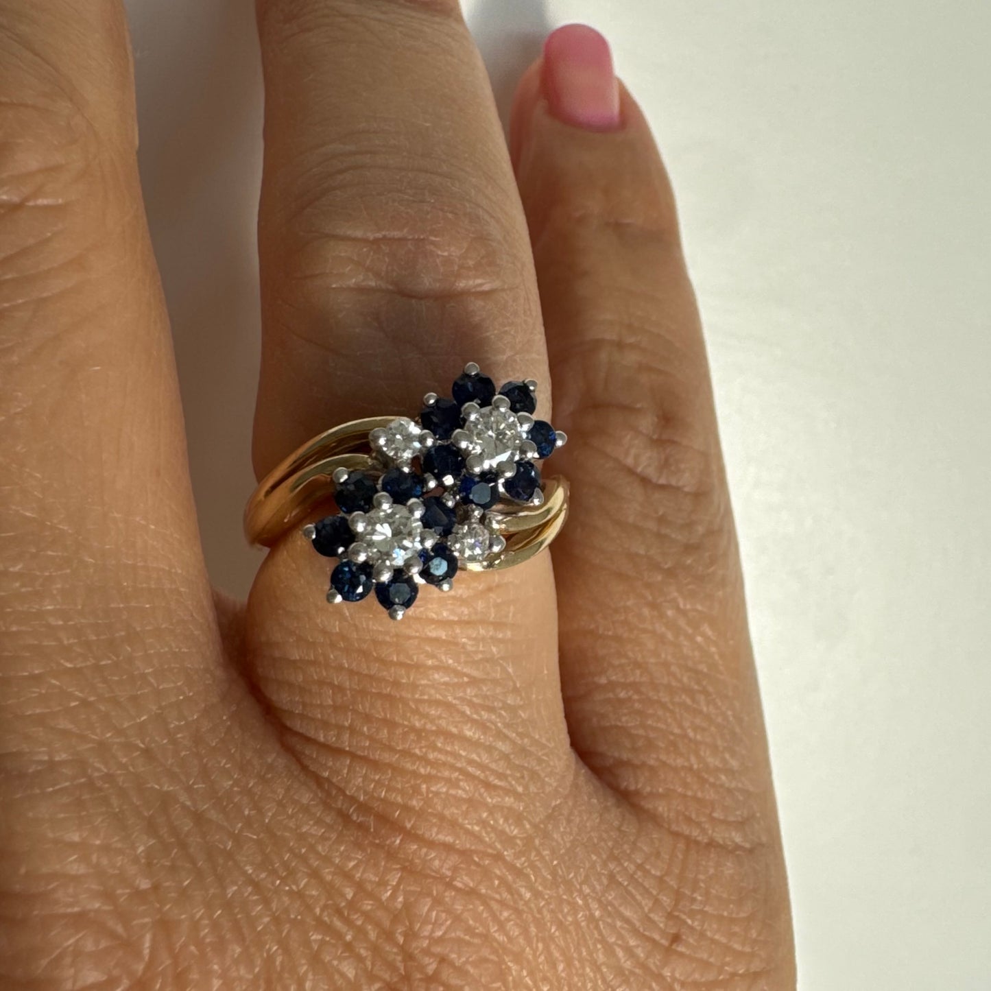 טבעת זהב צהוב 14 קראט משובצת אבני ספיר ויהלומים בעיצוב פרחים כפול.