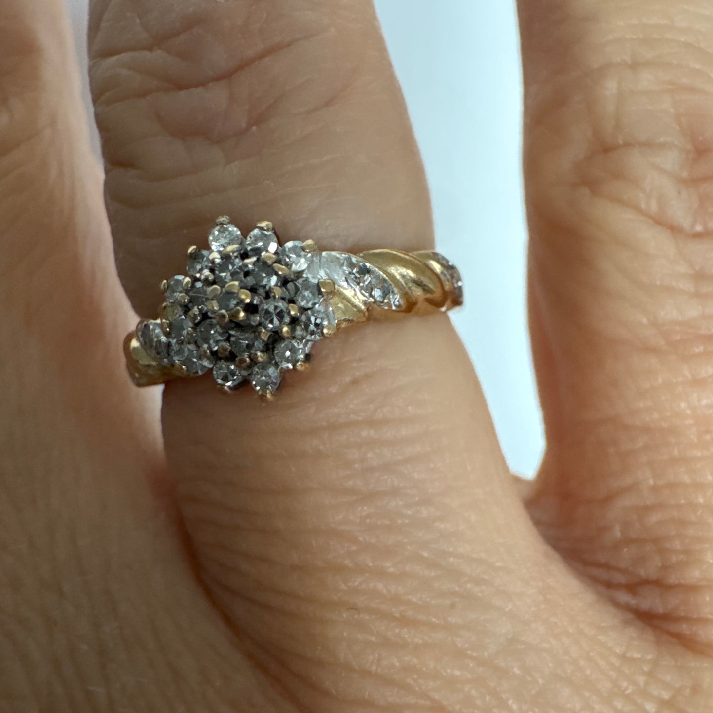 טבעת זהב צהוב 9 קראט משובצת יהלומים בעיצוב פרח עדין.