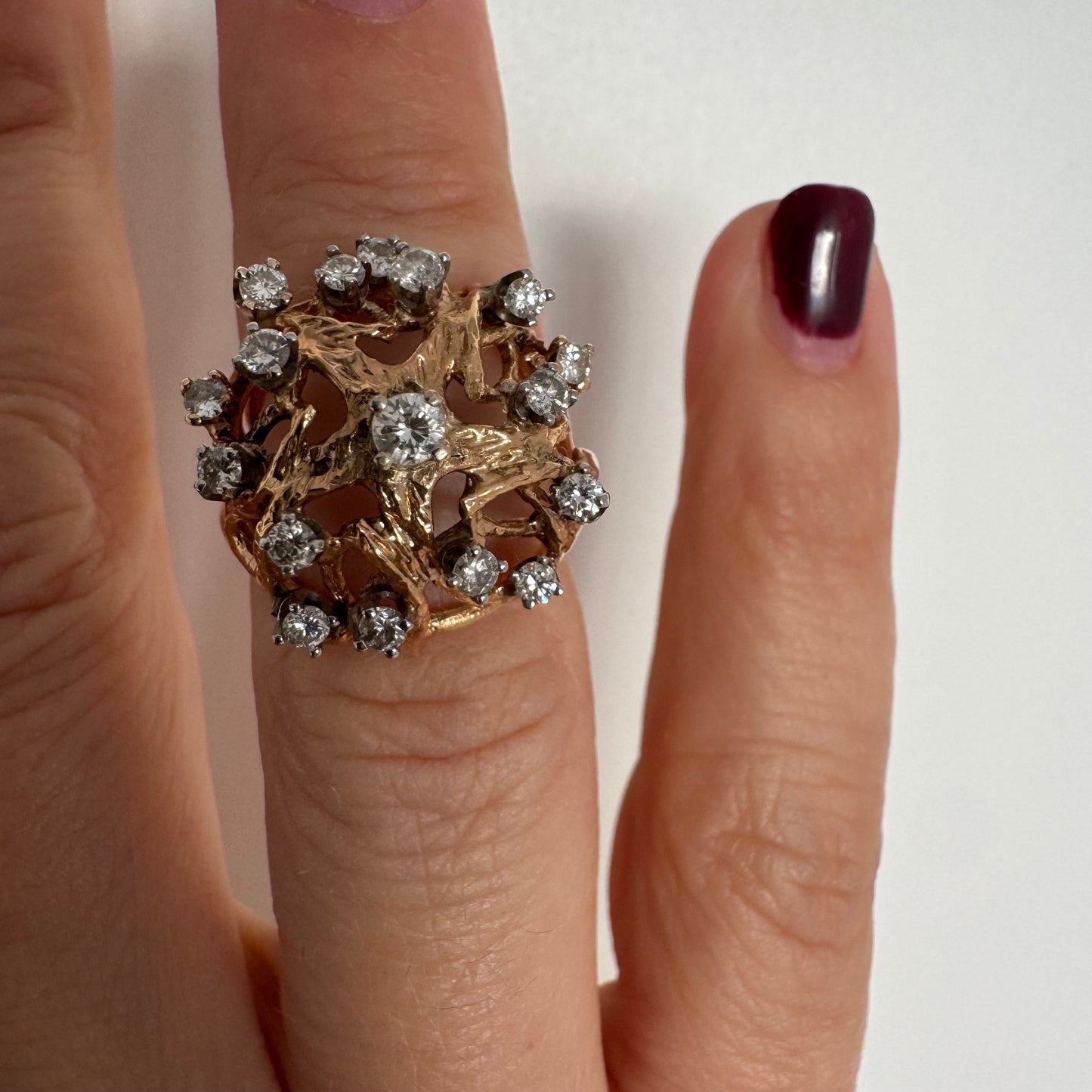 טבעת זהב 10 קראט בעיצוב פיסולי פתוח, משובצת יהלומים במבנה עגול דינמי.