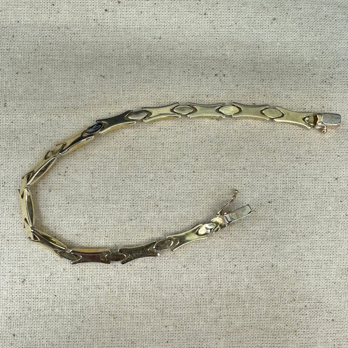 צמיד זהב צהוב וזהב לבן 14 קראט בעיצוב גאומטרי מיוחד, עם חיבורים בצורת X מזהב צהוב ושיבוצים מבריקים בזהב לבן