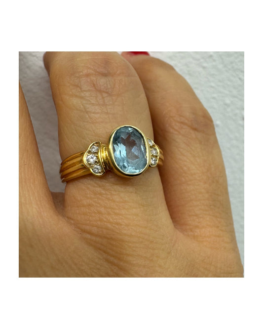 טבעת זהב 18 קראט משובצת אבן אקוומרין בגוון תכלת רך, עם יהלומים בצדדים שמוסיפים ברק עדין. 