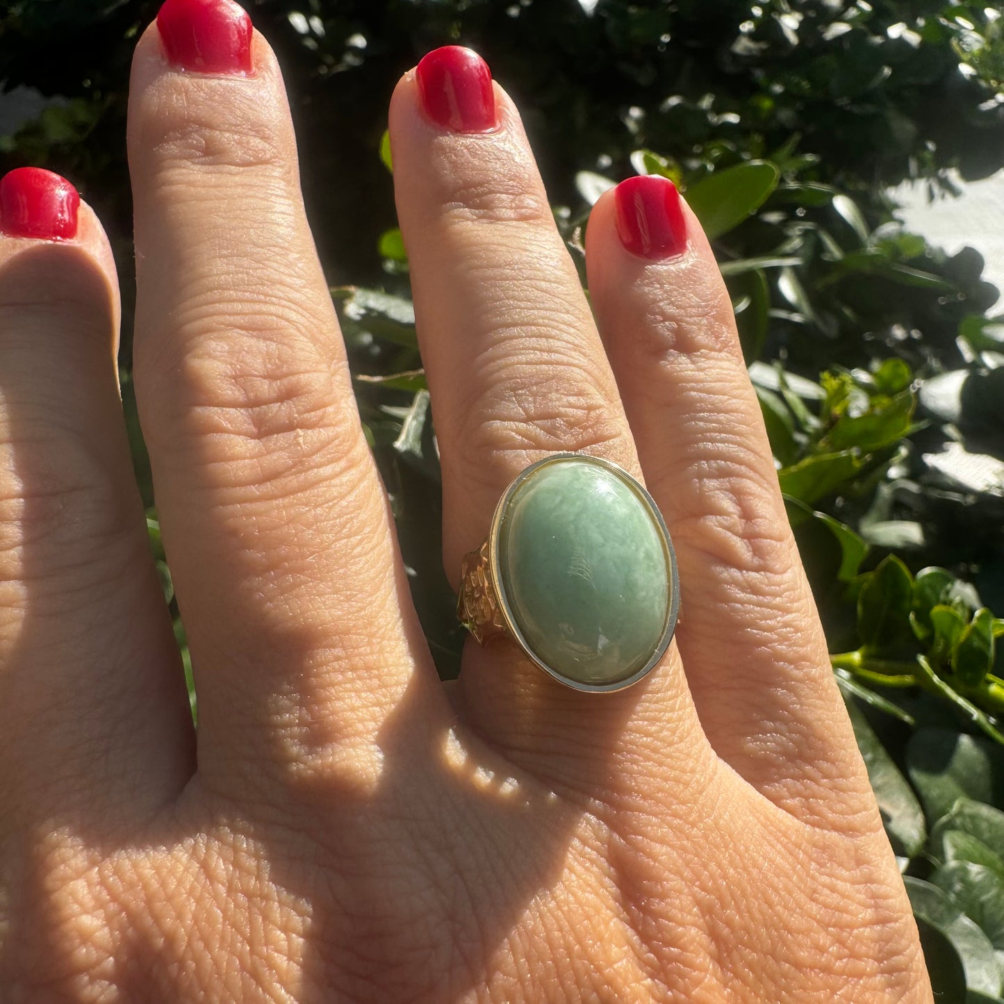 14K gold ring featuring a large oval light green Jade with a smooth polished finish, set in a classic bezel setting.