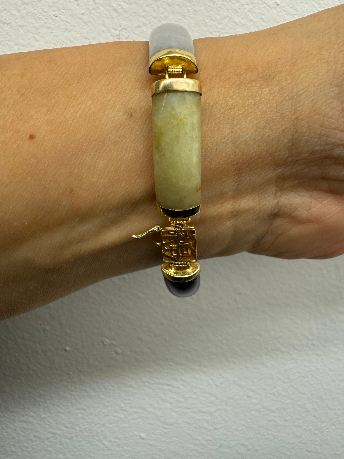 צמיד זהב צהוב 14 קראט עשוי מקטעי ג’ייד (jade) בשלושה גוונים – ירקרק, לבן ואדום – בשיבוץ זהב.