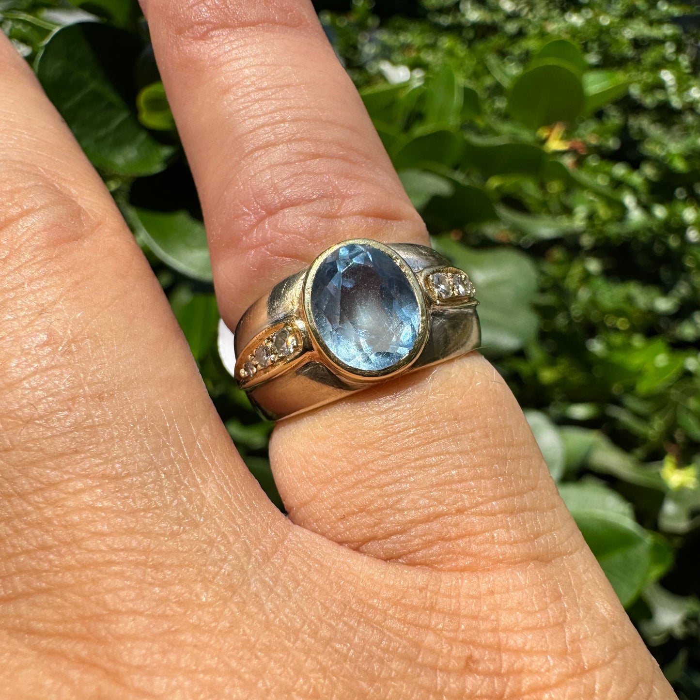 14K gold ring set with a luminous Blue Topaz at its center, accented by delicate side Diamonds