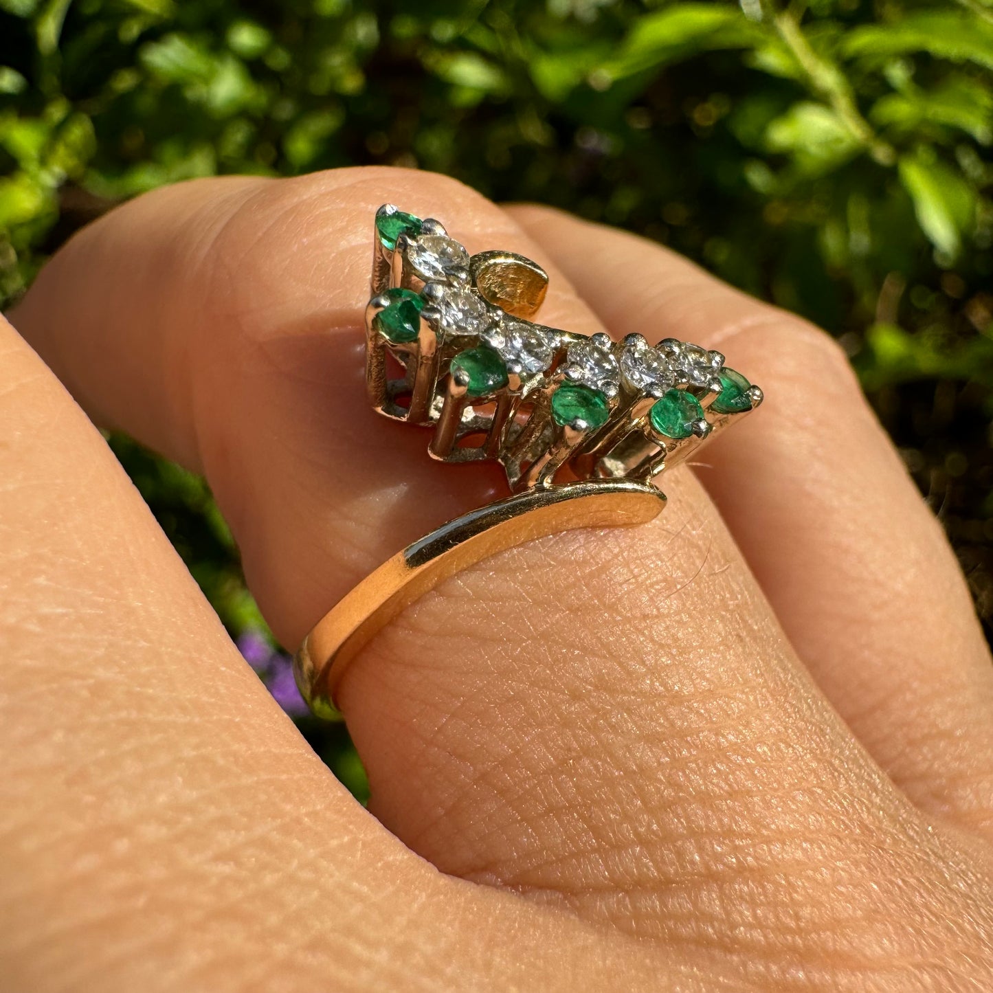 14K gold open ring featuring a delicate swirl set with Emeralds and brilliant-cut Diamonds