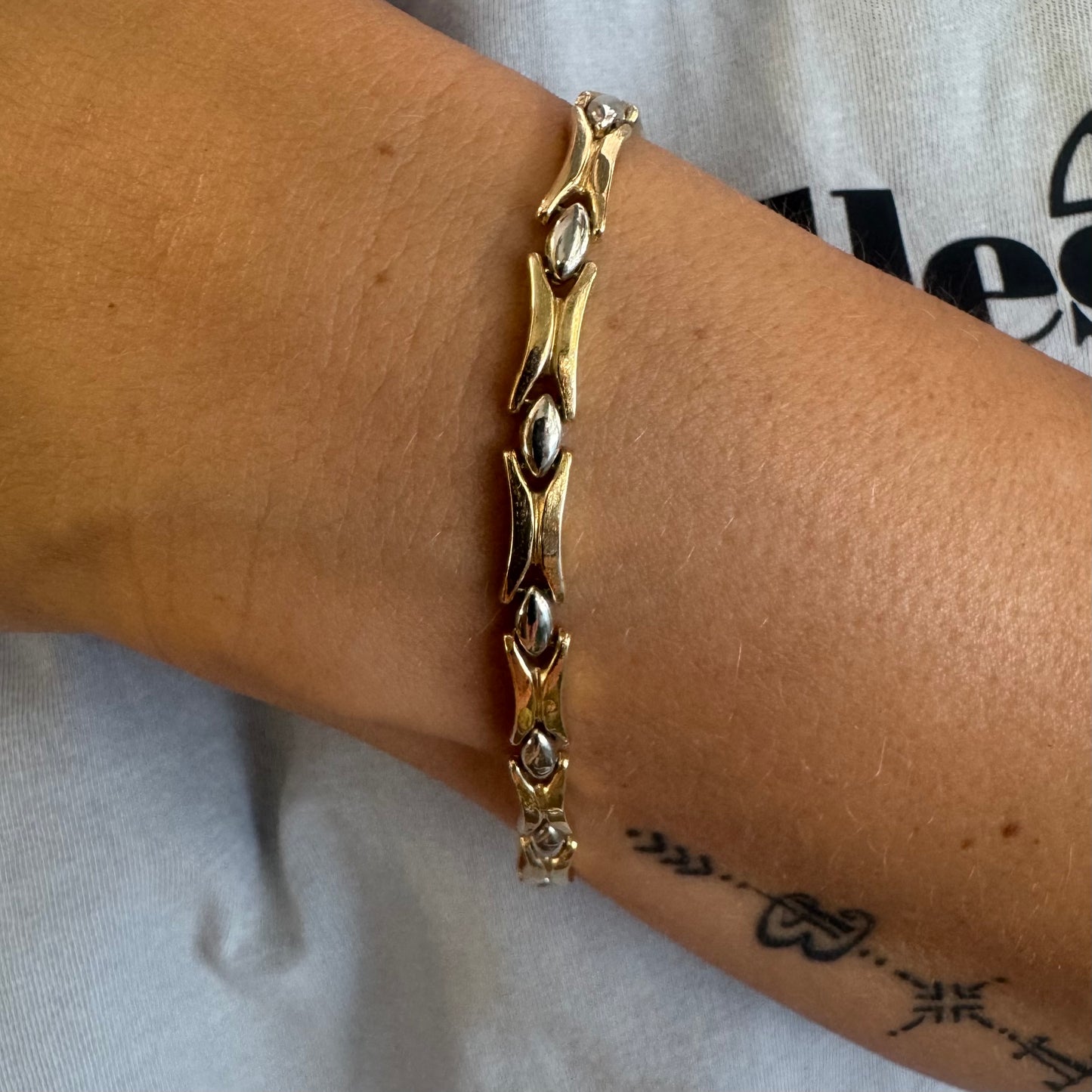 צמיד זהב צהוב וזהב לבן 14 קראט בעיצוב גאומטרי מיוחד, עם חיבורים בצורת X מזהב צהוב ושיבוצים מבריקים בזהב לבן