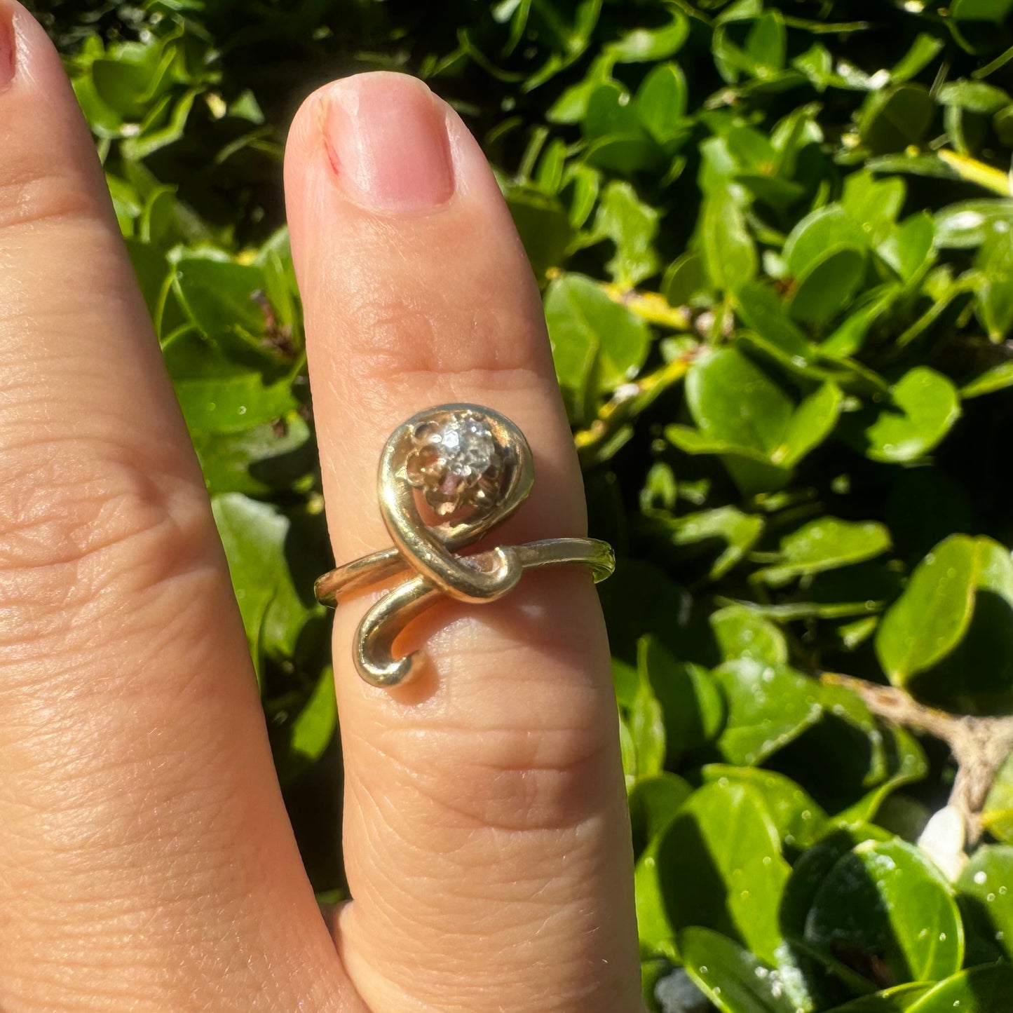 14K gold ring set with a brilliant-cut Diamond, embraced by a flowing, sculptural gold design