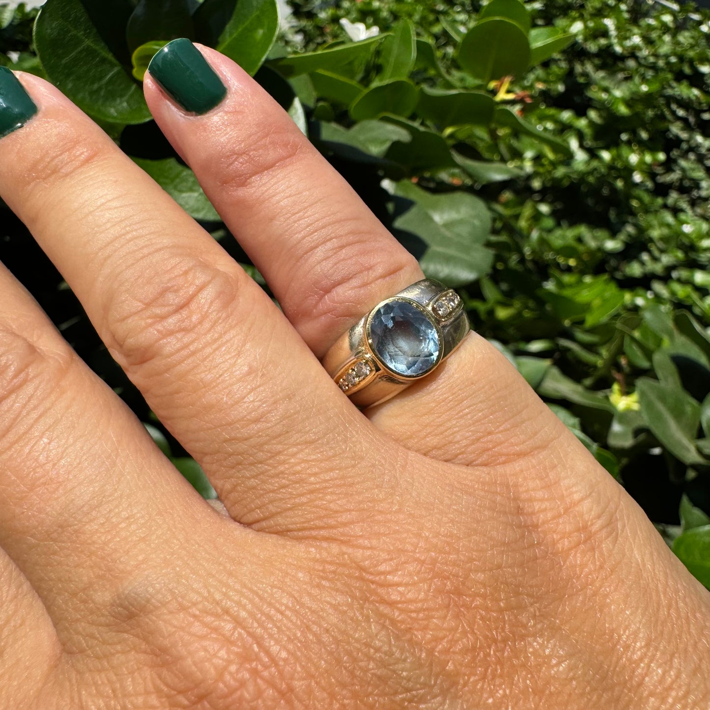 14K gold ring set with a luminous Blue Topaz at its center, accented by delicate side Diamonds