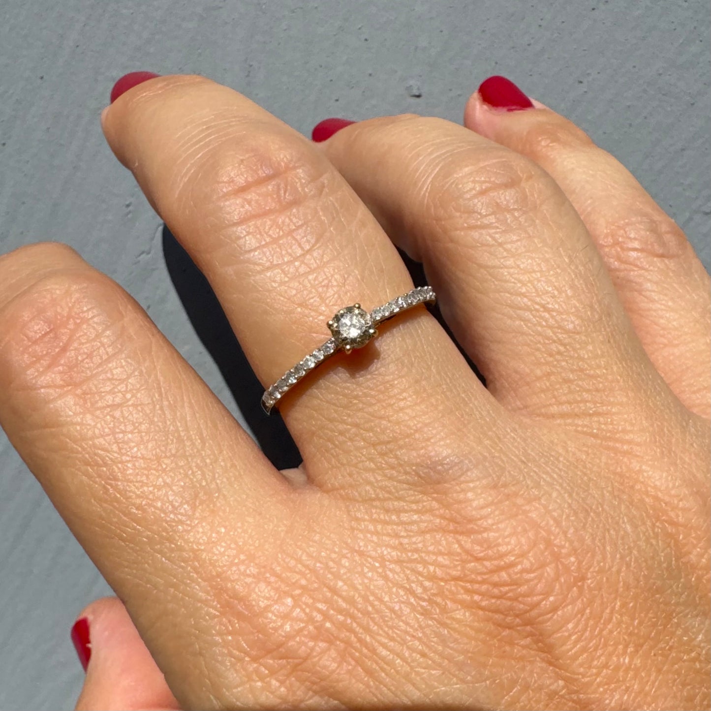 טבעת זהב 9 קראט משובצת יהלום מרכזי עדין, עם שיבוץ יהלומים נוספים לאורך הזרוע