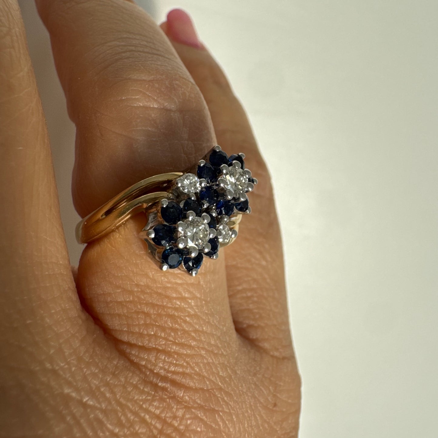 טבעת זהב צהוב 14 קראט משובצת אבני ספיר ויהלומים בעיצוב פרחים כפול.