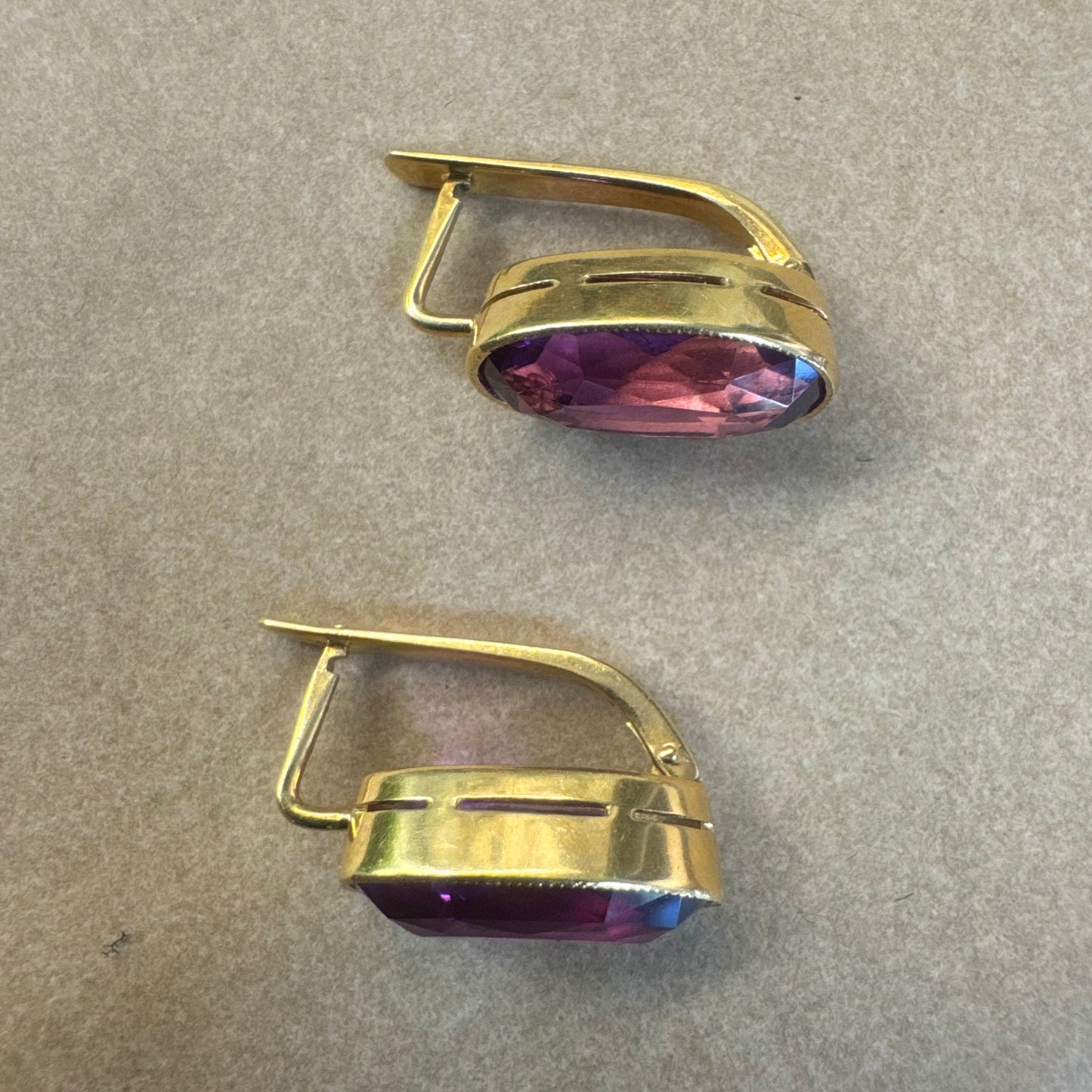 עגילי זהב צהוב 18 קראט, תלויים קצרים, משובצים באבני אמטיסט סגולות בחיתוך אובלי עמוק.