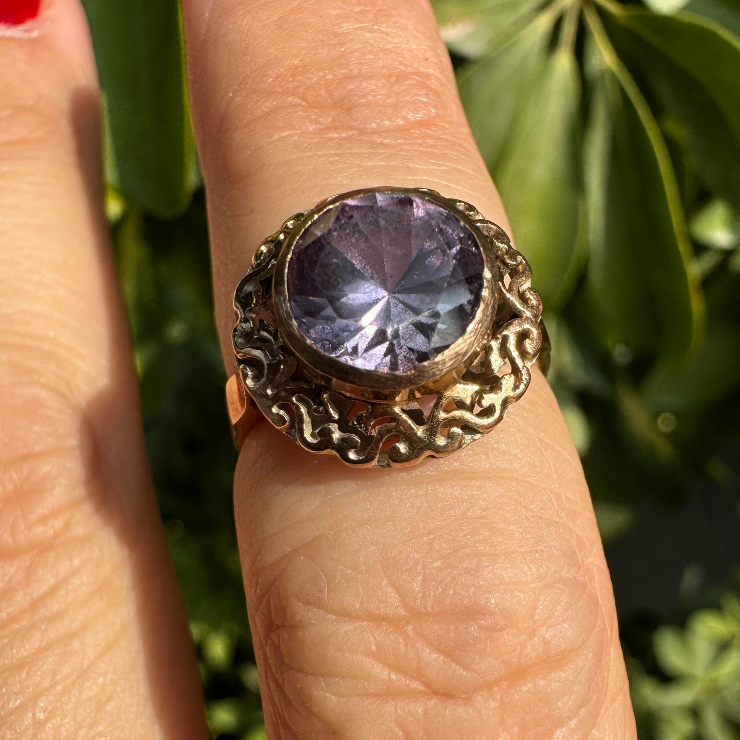 14K gold ring set with a large round-cut Tanzanite framed by an ornate filigree bezel