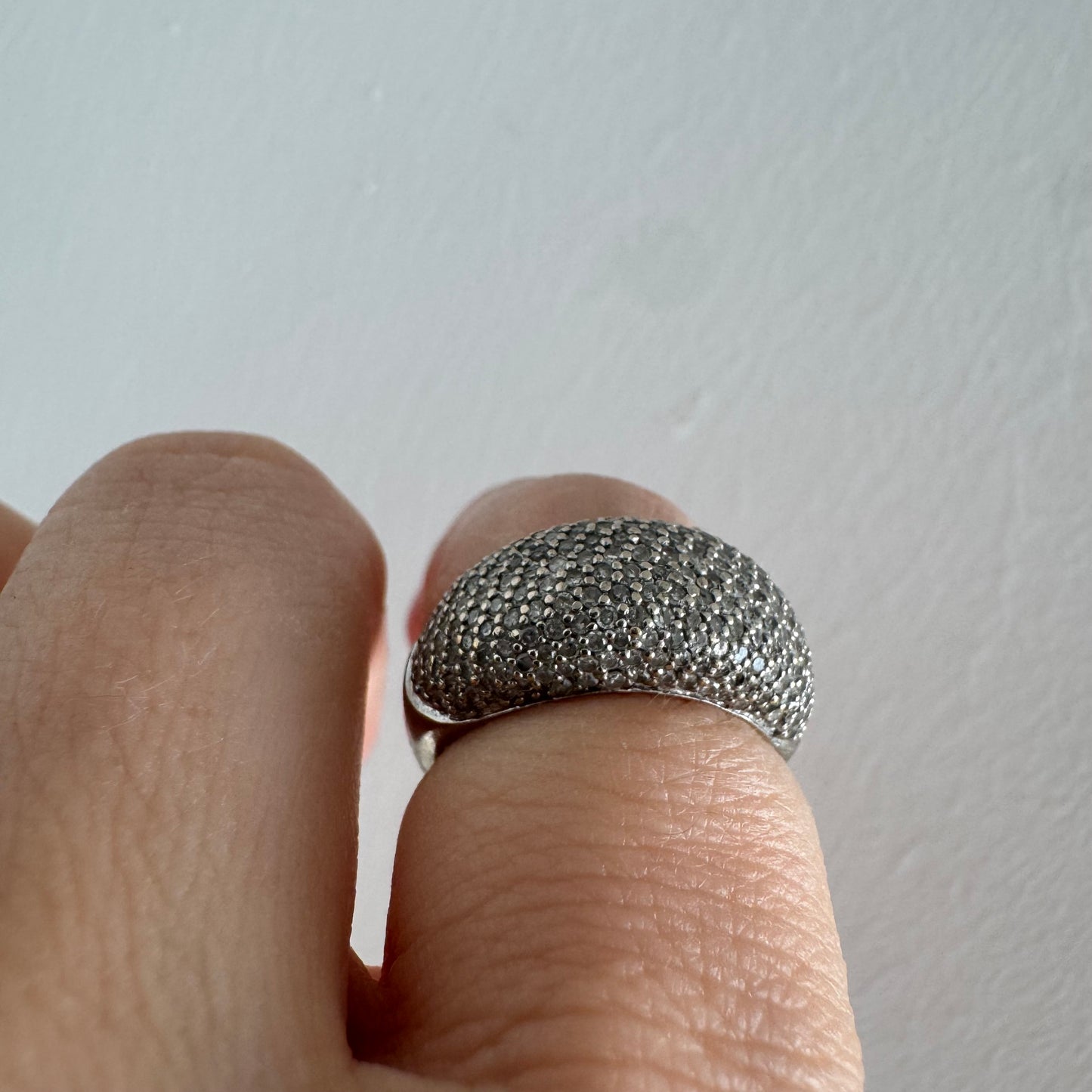 טבעת זהב לבן 14 קראט בעיצוב כיפה רחבה, משובצת יהלומים זעירים בשיבוץ פאבה צפוף.