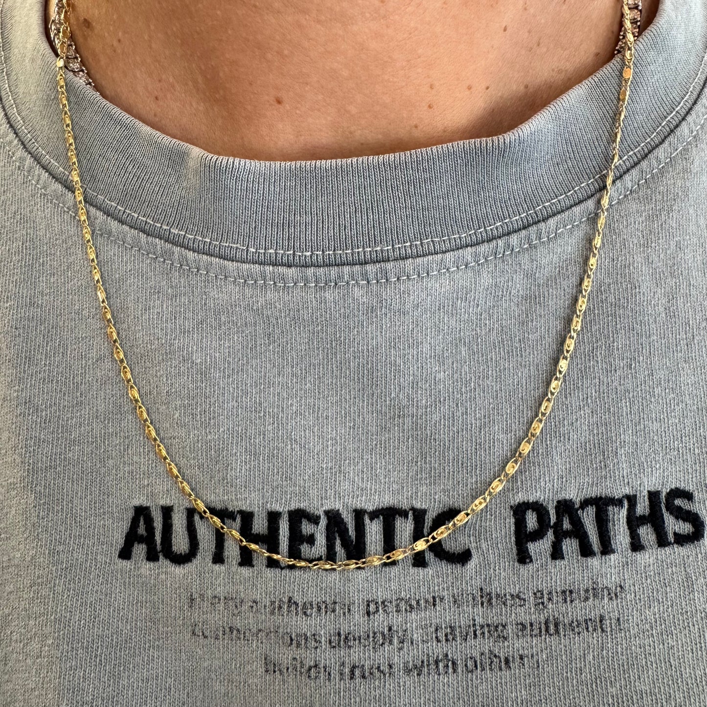 14K gold necklace featuring oval-shaped links with a subtle decorative pattern.