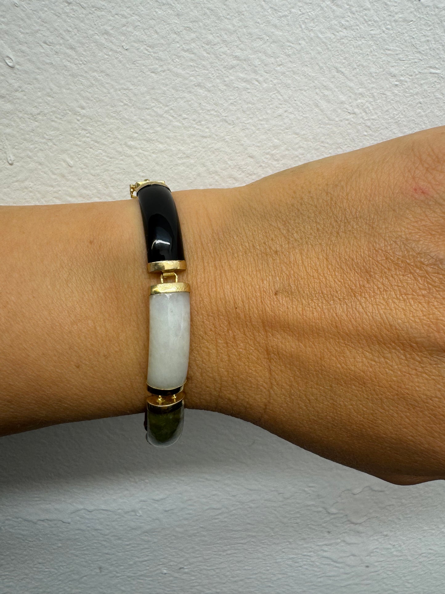 צמיד זהב צהוב 14 קראט עשוי מקטעי ג’ייד (jade) בשלושה גוונים – ירקרק, לבן ואדום – בשיבוץ זהב.