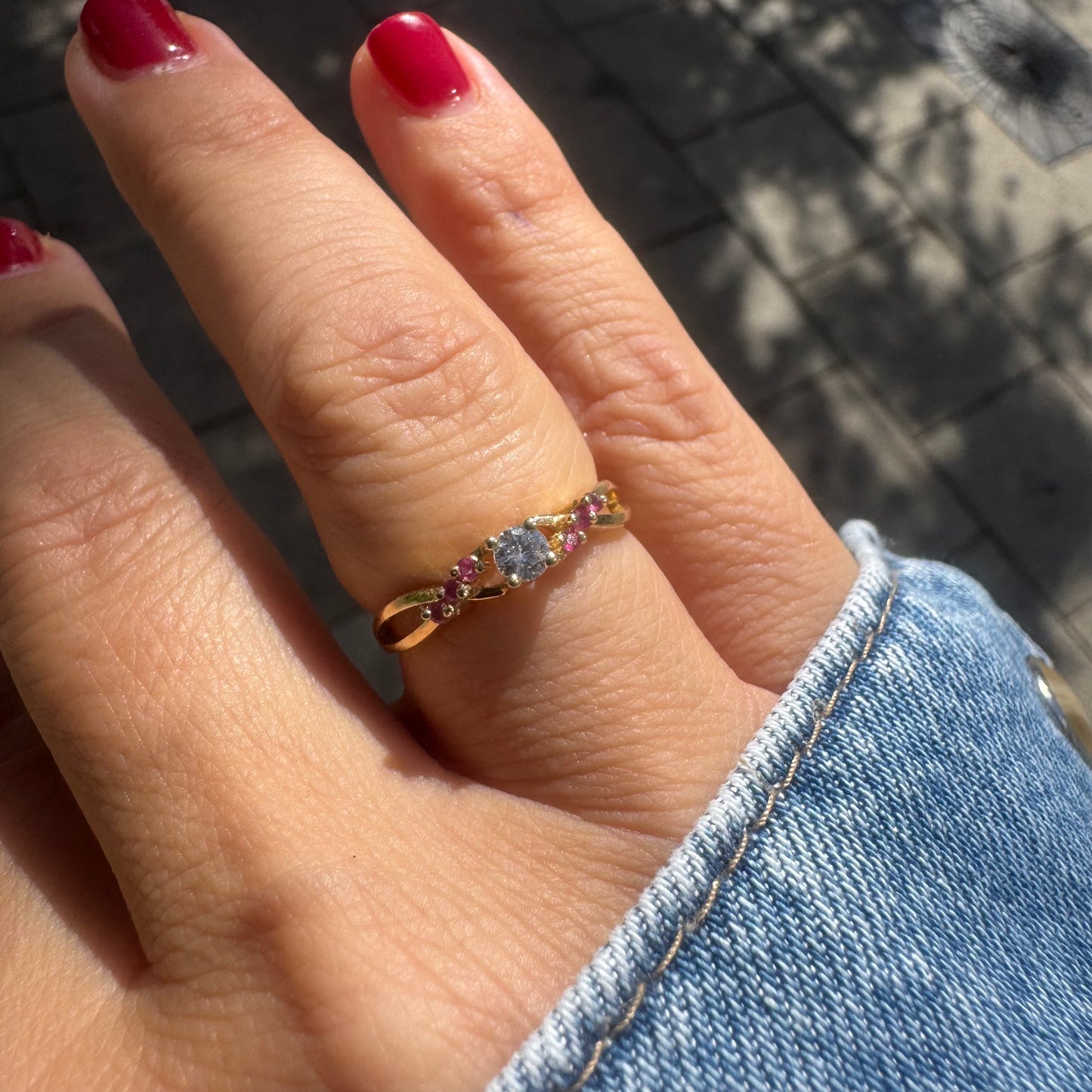 14K gold ring set with a central round Diamond, accented with Rubies along the band.