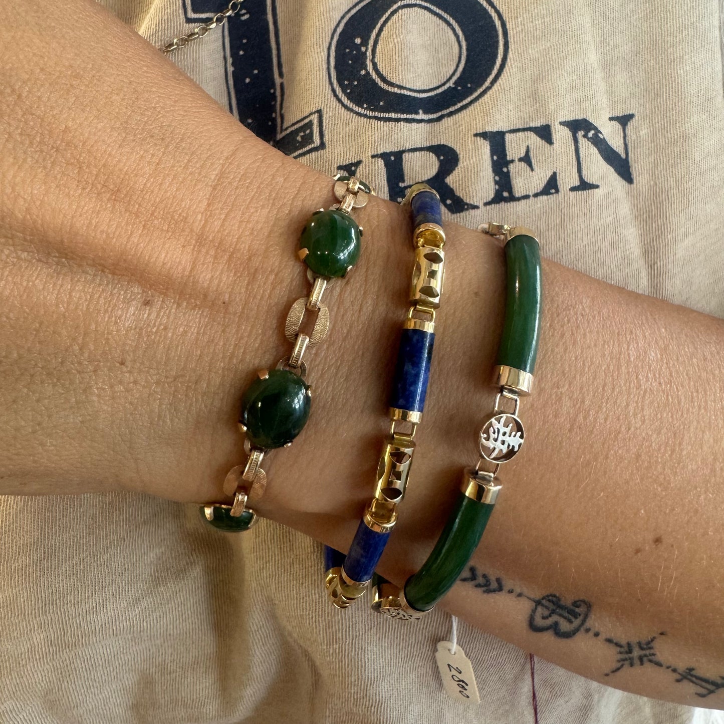 צמיד זהב צהוב 14 קראט משובץ באבני ג’ייד ירוקות בחיתוך קבושון (cabochon) בעיצוב אליפטי, המחוברות ביניהן בחוליות זהב עם טקסטורה מעניינת.