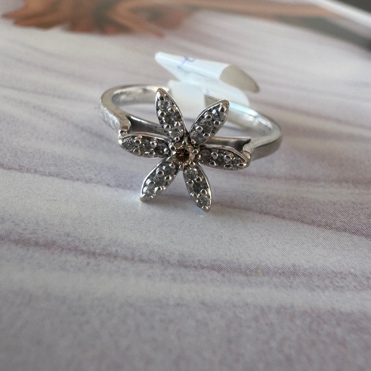 14K gold ring set with a floral design with six petal-shaped segments, each pavé-set with shimmering Diamonds