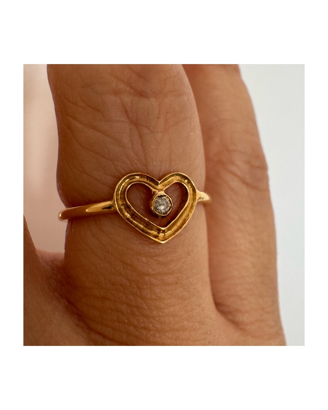טבעת זהב 14 קראט בעיצוב לב פתוח ועדין, עם יהלום קטן במרכז שמוסיף נקודת אור אלגנטית. 
