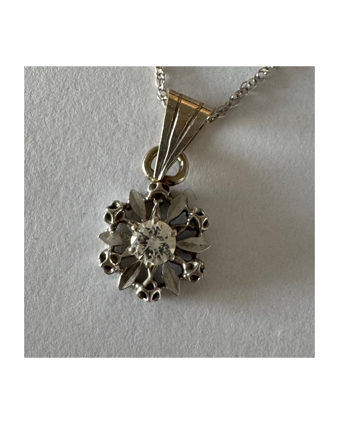 תליון זהב 14 קראט משובץ יהלום מרכזי בעיצוב פרח עדין ומלא נוכחות.