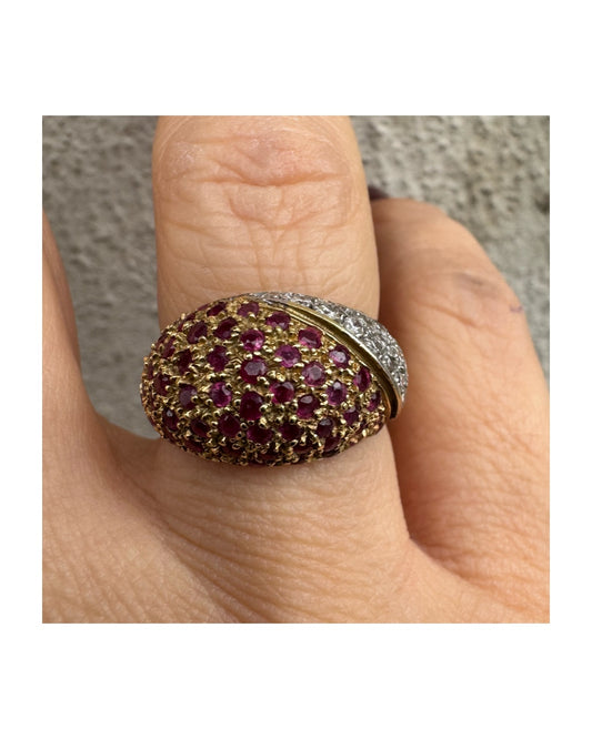 טבעת דום זהב צהוב 14 קראט ייחודית, משובצת חצי-חצי באבני רובי בצבע אדום-ורוד בוהק ויהלומים בשיבוץ פאווה צפוף.