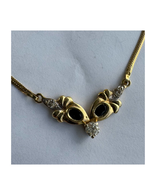 שרשרת זהב 14 קראט משובצת אבני ספיר כהות ויהלום מרכזי בחיתוך עגול. 
